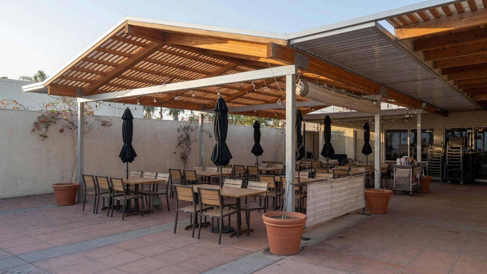 Covered restaurant patio seating with warm architectural shade structure